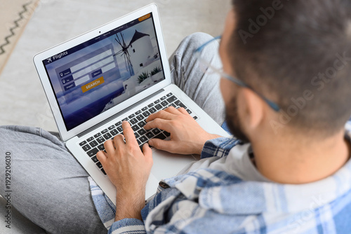 Young man using laptop to s...