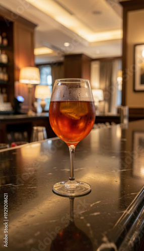 Glass of drink on bar counter in hotel lounge during evening hours with soft lighting and cozy atmosphere