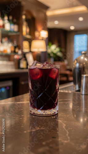Refreshing drink served in a clear glass on a dark countertop in a bar setting during the evening hours
