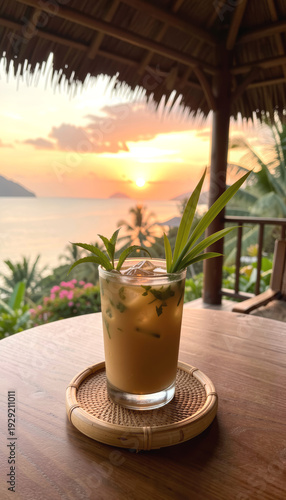 Refreshing iced drink with mint and pandan leaves on a wooden table at sunset. Tropical vacation and relaxation concept