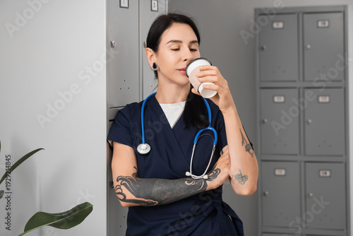 Tattooed female doctor drin...