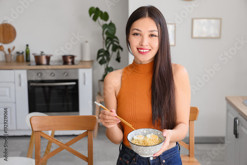 Young Asian woman eating ta...