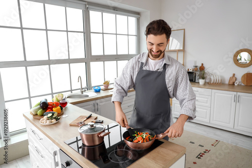 Handsome bearded man frying...