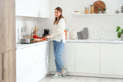Young woman cutting carrot ...