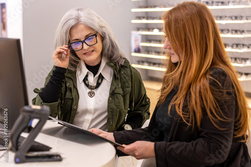 Φωτογραφία Active stylish woman over 50 buying fashionable eyeglass frames in a premium opt