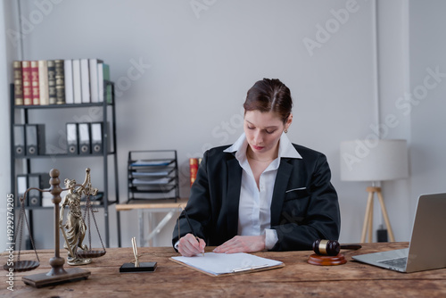 Female lawyer reviewing and signing legal documents, demonstrating professionalism and focus while managing agreements and paperwork in a law office environment, symbolizing justice and expertise