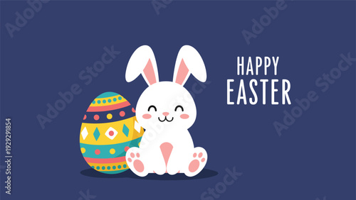 Cute white bunny sitting next to a colorful decorated easter egg on dark blue background for festive holiday greeting cards.