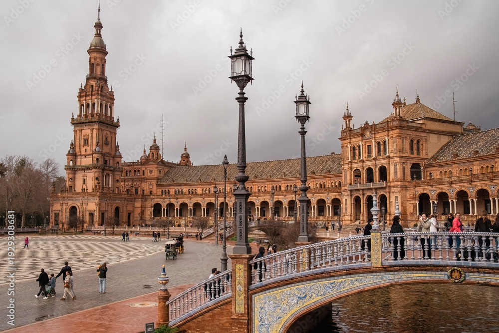 Obraz premium Plaza de Espana, Sivilla. Historic stone building with towers and courtyard under cloudy sky