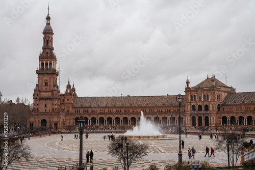 Plaza de Espana, Sivilla. Historic stone building with towers and courtyard under cloudy sky