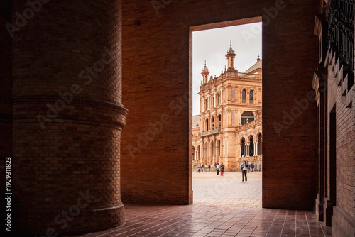 Plaza de Espana, Sivilla. Historic stone building with towers and courtyard under cloudy sky