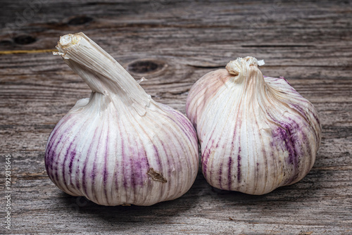 2 heads of pink garlic on a rustic background on a wooden table