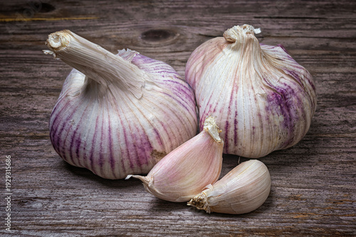 2 heads of pink garlic on a rustic background on a wooden table