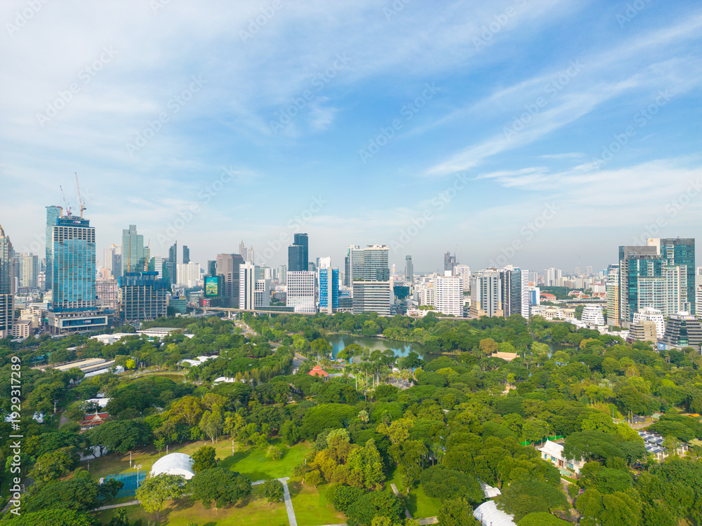 Fototapeta premium Aerial view modern office building with green tropical Lumpini park forest blue sky business travel background Bangkok Thailand