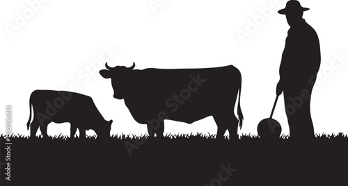 Black silhouette of man with hat standing next to two grazing cows on grass