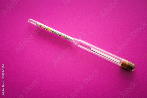 Tableau sur toile ​A glass household hydrometer with a bright colored scale is positioned diagonally on a rich purple background
