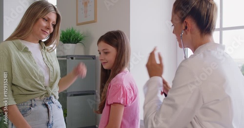 Wallpaper Mural Pediatrician using stethoscope on girls back to examine lungs during routine examination in modern clinic. Auscultation checkup on healthcare consultation for child, doctor listening to kids breathing Torontodigital.ca
