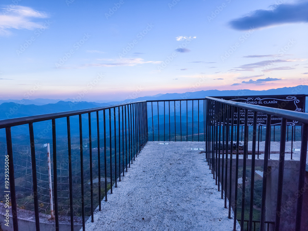 Fototapeta premium A metal railing overlooks a beautiful mountain range