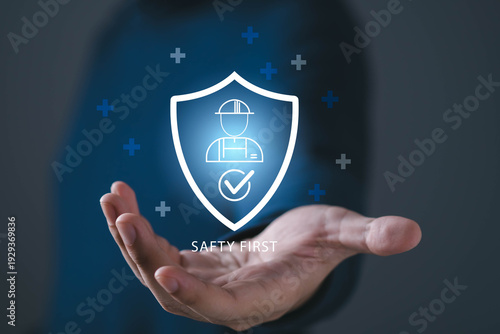 Workplace safety and health protection concept with shield and worker icon above hand. Ideal for occupational safety, construction safety, compliance, insurance, and corporate responsibility visuals.