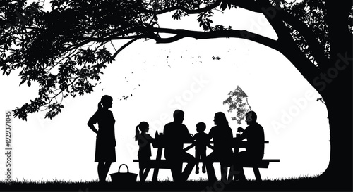 Silhouette of a happy multi-generational family having a picnic lunch at a wooden table under a large shade tree outdoors.