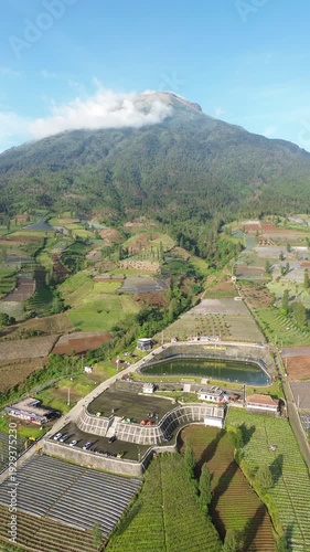 Aerial View of Mountain Terraced Farmland and Reservoir Near Village on a Clear Sunny Day