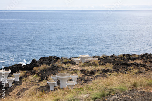 Mesas de piquenique na paisagem costeira da Ilha Terceira, Açores