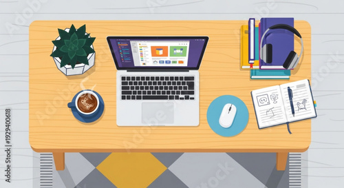 Home office workspace with laptop books plant coffee and stationery on wooden desk from above