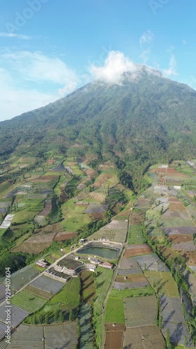 Aerial View of Mountain Terraced Farmland and Reservoir Near Village on a Clear Sunny Day