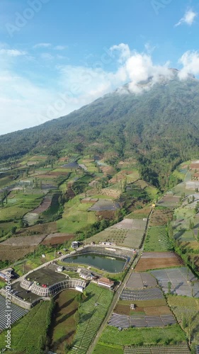 Aerial View of Mountain Terraced Farmland and Reservoir Near Village on a Clear Sunny Day
