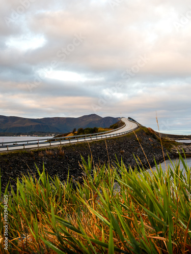 Storseisund Bridge from Eldhusøyan Island at Sunrise, Winding Coastal Road, Golden Morning Light, Scenic Grass Foreground, Travel and Landscape Photography