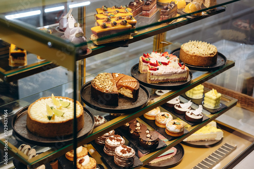 Assorted cakes and pastries displayed in a glass bakery case for dessert lovers and celebrations