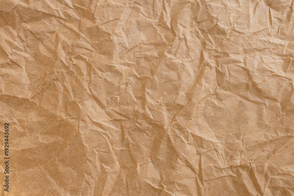 Fototapeta premium Crumpled Brown Kraft Paper Texture Background,Top view of brown crumpled recycled kraft paper texture. Abstract wrinkled paper background with rough creases and shadows, perfect for organic,