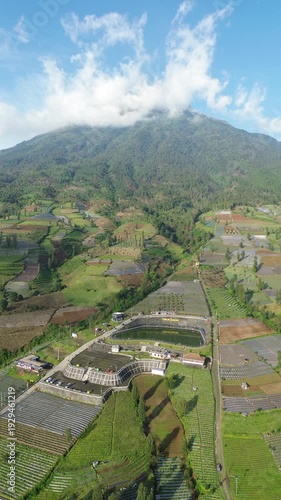 Aerial View of Mountain Terraced Farmland and Reservoir Near Village on a Clear Sunny Day