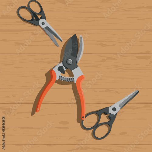 Various gardening and household cutting tools, including pruning shears and scissors, laid out on a wooden table.