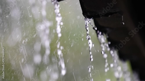 Raindrops cascading from a roof, highlighting the elements' beauty and power