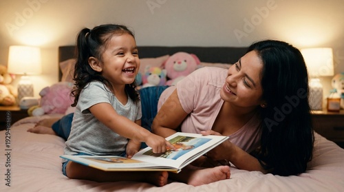National Reading Day bedtime story moment with laughing Latina toddler girl and mother reading picture book in cozy bedroom for educational content design