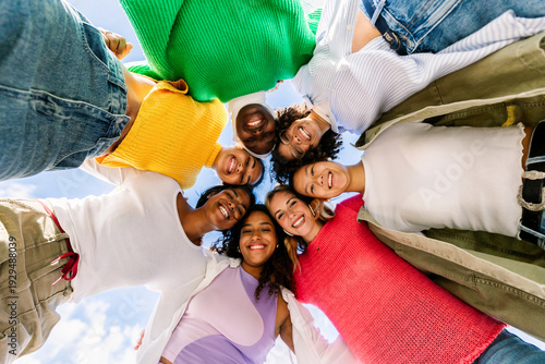 Fotografie Diverse female friends looking down in a circle smiling