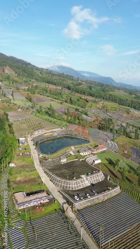 Aerial View of Mountain Terraced Farmland and Reservoir Near Village on a Clear Sunny Day
