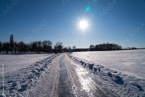 Ukrainian village. Seasonal landscape. Winter road and cold sun