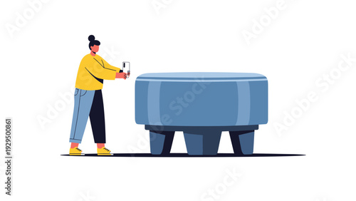 Young woman in a yellow sweater and blue jeans uses her smartphone to take a photo of a large blue upholstered ottoman.