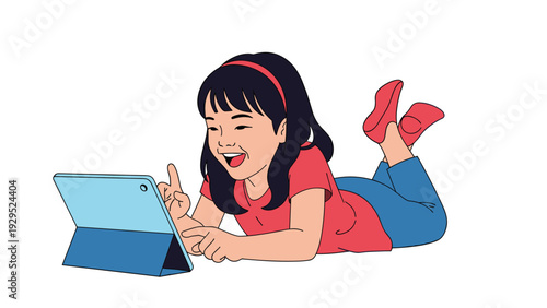 Little girl lying on her stomach and happily using a tablet computer while relaxing on a plain white background.
