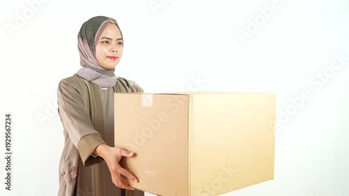 Muslim Woman with Smiling Expression and Holding Cardboard Box Gesture Isolated on White Background In Studio Lighting. 4k Video