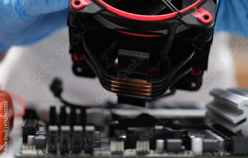 Technician installing CPU cooler on computer motherboard
