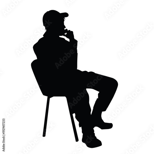 Silhouette of a young man sitting in a modern armchair