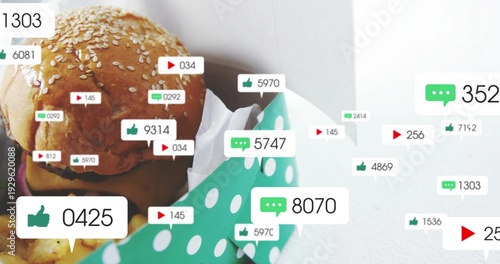 Showing sesame burger in green dotted takeout box on tabletop with white paper, fries, social icons