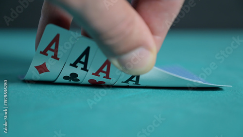 Close-up image of a poker hand revealing four aces on a green casino table. Dramatic gambling scene symbolizing luck, winning, risk, strategy, and success. Focus on playing card detail and tension 