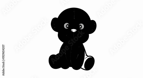 A black teddy bear sits with its eyes wide open and a smiling mouth