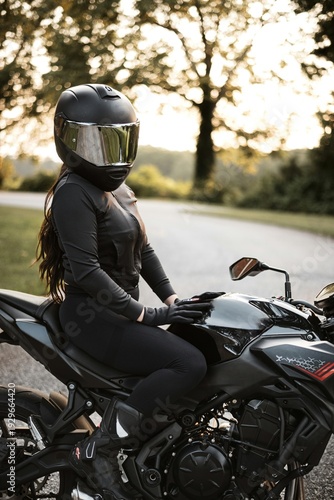 Female motorcyclist riding sport motorcycle at sunset outdoors