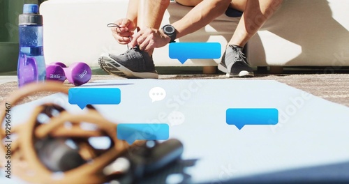 Fotografie Tying fit man wearing shorts tightening shoe laces in living room, with mat, jum