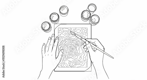 Top-down view of hands painting an abstract pattern on paper with paint pots nearby