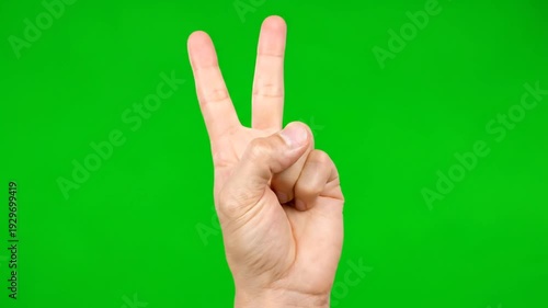A hand counting three fingers in a VIDEO on a green screen with studio lighting